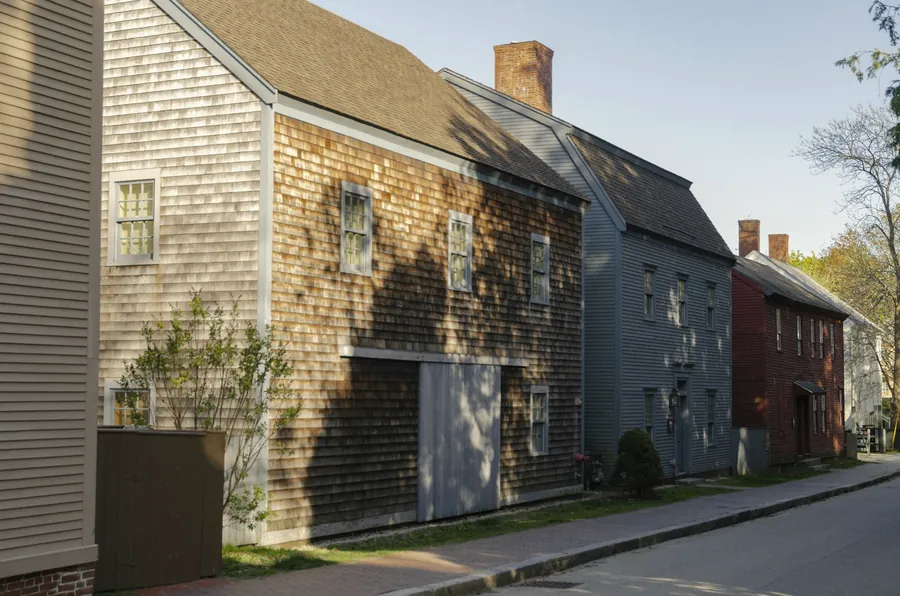 Weathered shingled houses along a quiet street in early summer
